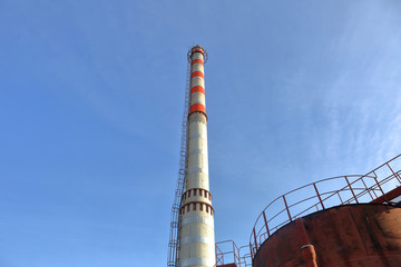 High red and white water tower on a sunny day against the blue cloudless sky