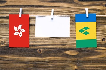Hanging flags of Hong Kong and Saint Vincent And The Grenadines attached to rope with clothes pins...
