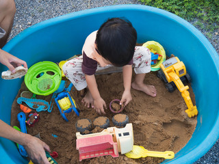 Asian child boy playing car truck toy and sand in sandbox with happy face outdoor with rural...