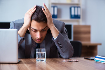 Sick male employee suffering in the office