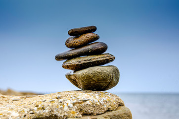 Pyramid of sea pebbles on a background of the sea.
