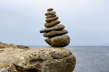 Pyramid of sea pebbles on a background of the sea.