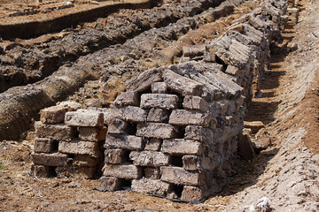 Pile of stacked bog peat turf briquette