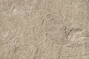 Textured wall of rough plaster as a sand colored background