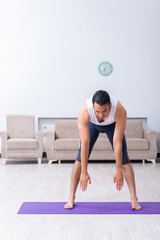 Fototapeta premium Young man training and exercising at home