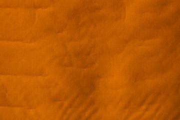 Real orange canvas with wrinkles as a background.