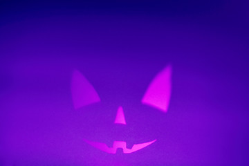 Halloween scary face on violet background. Scary smile face. Holiday horror background