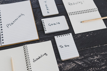 setting up for success, business desk with notebooks with elements from planning to scheduling tasks and getting results