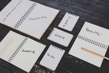 setting up for success, business desk with notebooks with elements from planning to scheduling tasks and getting results