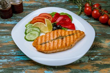 Salmon steak on the grill on wooden table