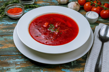 Borscht with sour cream on wooden table