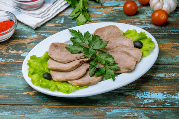 Beef tongue with horseradish on wooden table