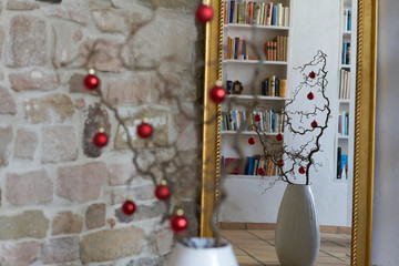Fototapeta na wymiar Christmas decoration with red balls in beautiful loft with mirror and stone wall