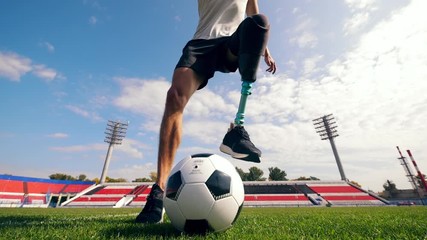Paralympic football player is dribbling the ball - Powered by Adobe