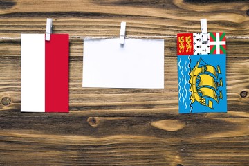 Hanging flags of Indonesia and Saint Pierre And Miquelon attached to rope with clothes pins with...
