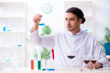 Male chemist examining wine samples at lab