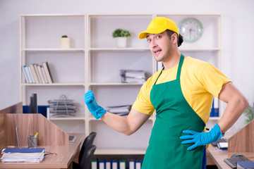 Young male contractor cleaning the office