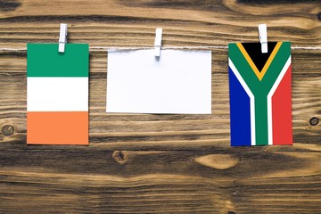 Hanging flags of Ireland and South Africa attached to rope with clothes pins with copy space on...