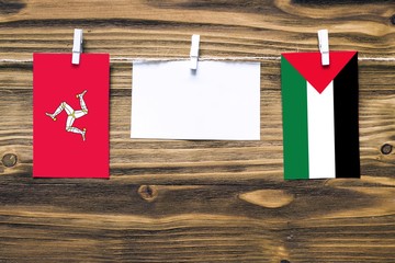 Hanging flags of Isle Of Man and Palestine attached to rope with clothes pins with copy space on...