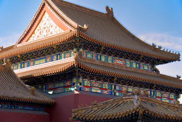 Fototapeta na wymiar curved roofs in traditional Chinese style with figures on the blue sky background. The Imperial Palace in Beijing