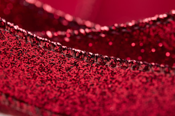 Obraz premium Macro abstract texture view of glittering defocused red fabric ribbon with bokeh