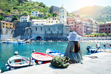 happy tourist woman looking at scenic view of old village Vernazza, Cinque Terre, Liguria, Italy