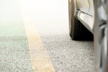 Beside of car blurred to focus tire. Stop on street with yellow line. Movement to the intended goal. © thongchainak