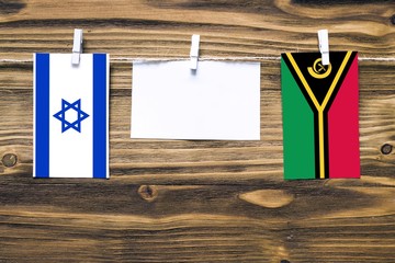 Hanging flags of Israel and Vanuatu attached to rope with clothes pins with copy space on white...