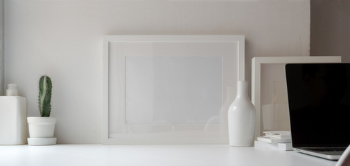 Minimal office room with mock up frame and decorations on white wooden table