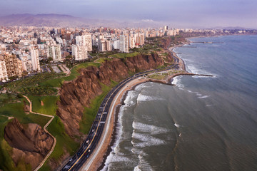 Aerial view of the Costa Verde highway, the sea, the cliff and de Lima city at sunset, in Lima, Peru. 