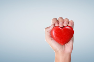 Obraz premium Hands holding a red heart, heart health