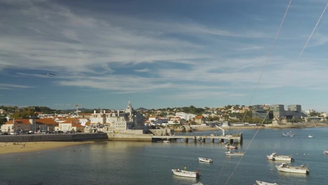 White woman taking picture of one of the beautiful landscapes of Cascais, Portugal.