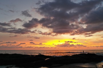 Fototapeta na wymiar Fishermen beside sea at sunset 