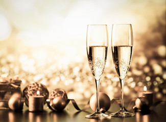 two champagne glasses against holiday lights and fireworks - new year celebration