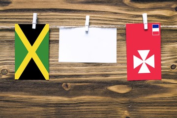 Hanging flags of Jamaica and Wallis And Futuna attached to rope with clothes pins with copy space...