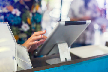 Selective to tablet. Cashier staff using tablet to receive orders from customers at counter service...