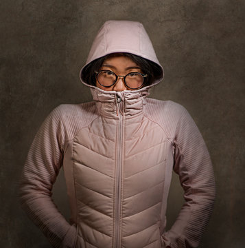 portrait of young sweet and nerd Asian Korean teenager student woman wearing glasses and hood jacket in hipster and nerdy style isolated on studio background