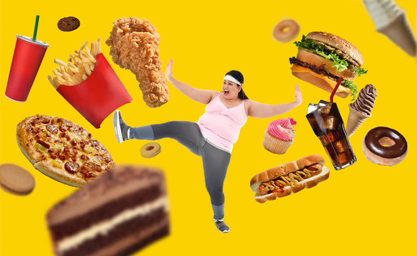 Overweight Asian woman fighting off junk food