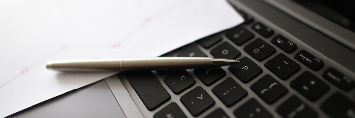 Obraz premium Laptop black keyboard with pen paper