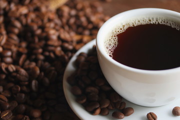 cup of coffee and beans on wooden background