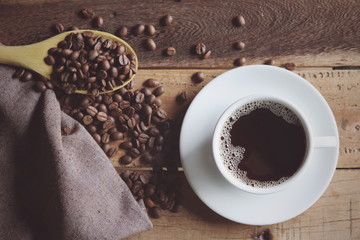 cup of coffee and beans on wooden table