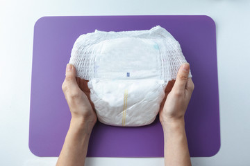  The woman is holding baby diapers in her hands.