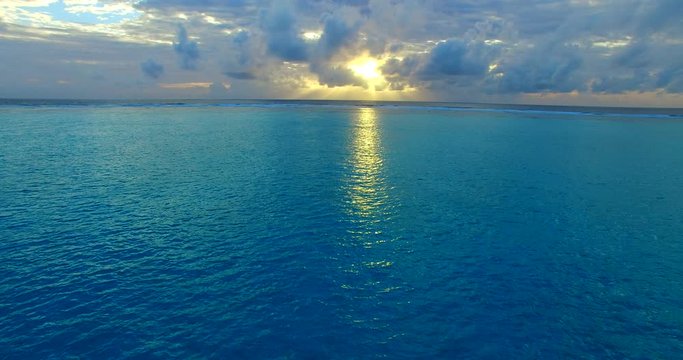 sun behind the clouds, the majestic sunset over Barbados coral reefs, dramatic sky with fluffy clouds over Atlantic ocean