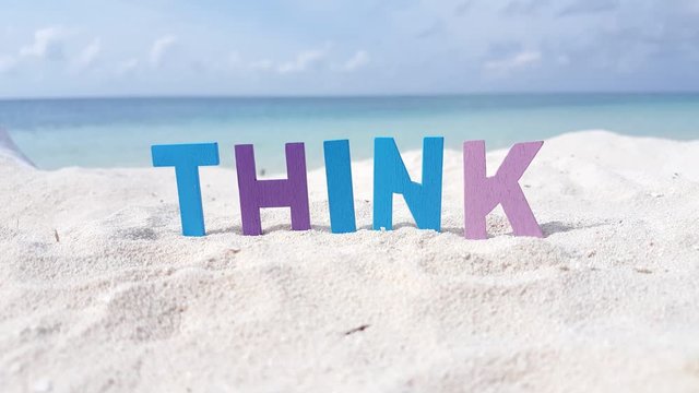 Word THINK formed from wooden 3d letters on the tropical sandy beach. creative thinking concept