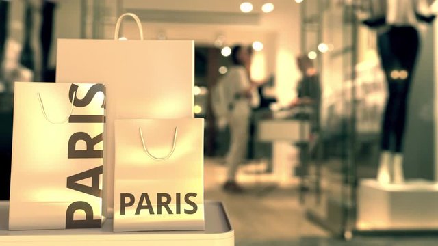 Shopping bags with PARIS text against blurred store. French shopping related clip