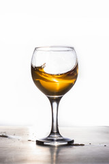 Amber wine. A splash of liquid in a glass. Traditional wine according to ancient Georgian technology. Copy space Close-up and vertical orientation.