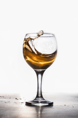 Amber wine. A splash of liquid in a glass. Traditional wine according to ancient Georgian technology. Copy space Close-up and vertical orientation.