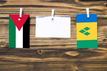 Hanging flags of Jordan and Saint Vincent And The Grenadines attached to rope with clothes pins...