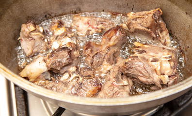 Lamb meat is fried in a pan