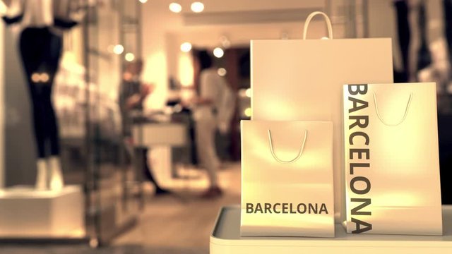 Shopping bags with BARCELONA text against blurred store. Spanish shopping related clip